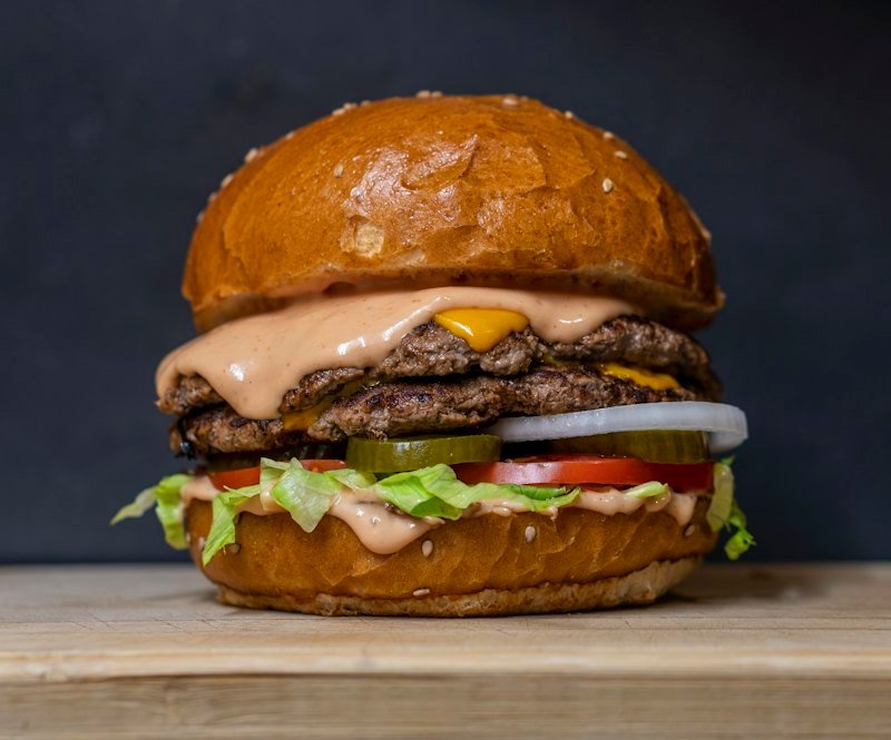 Stacked burger with cheese, lettuce and tomato